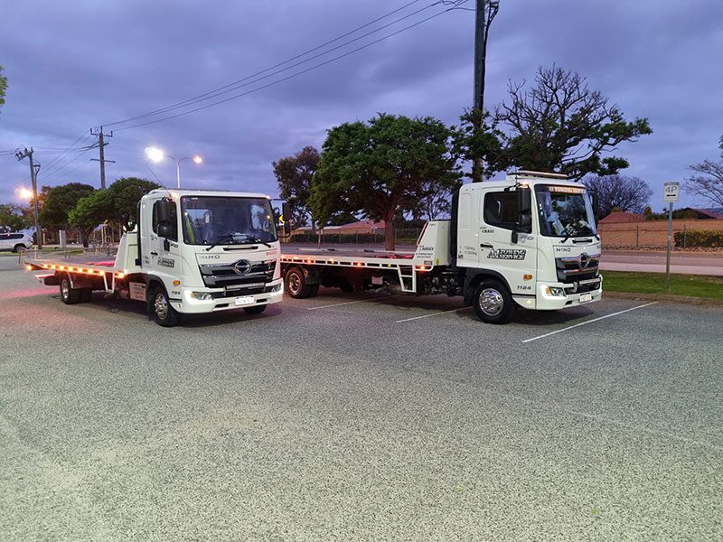 two white trucks side by side a1 towing services